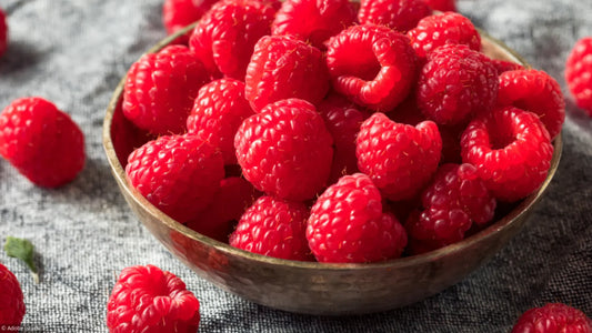 Gros plan de framboises fraîches rouges et juteuses, montrant leur texture granuleuse. Parfait pour illustrer des sujets liés à la santé, la nutrition ou les recettes.