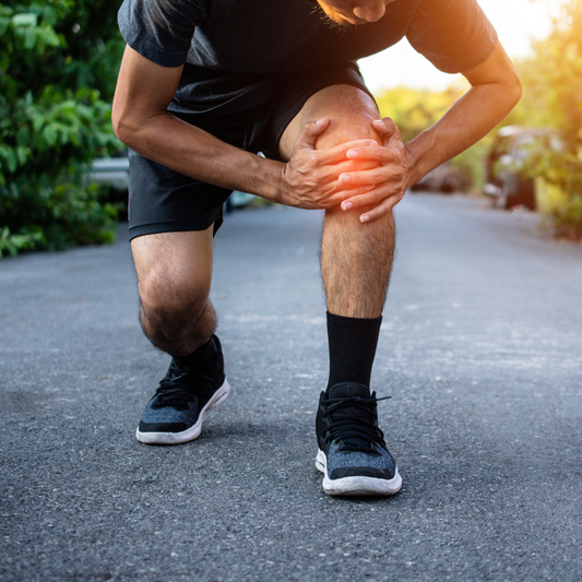 Personne ressentant des douleurs articulaires, soulignant l'importance d'une alimentation riche en antioxydants pour soulager l'arthrose.